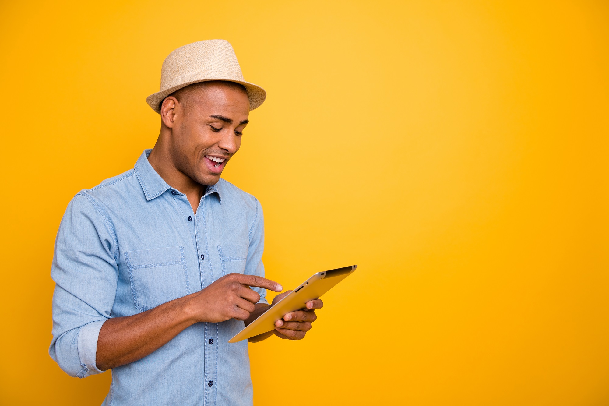 Proifile side photo of focused, cheerful youth use user device check voyage isolated over yellow background